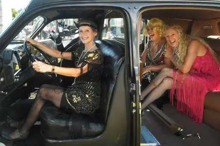 women dressed in roaring 20's costumes smiling and laughing