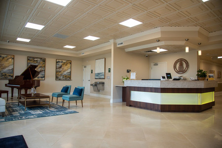 suntree senior living community lobby with a piano and large desk