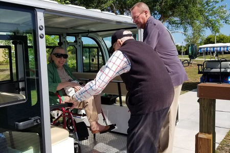 Woman in wheel chair being helped onto tram