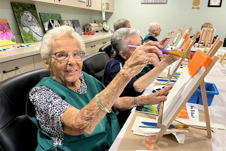 Senior women in art class painting