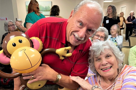 lady and man smiling with balloon monkey
