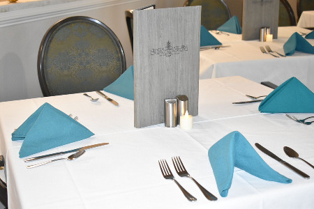 Table setting with white table cloth and blue napkins 
