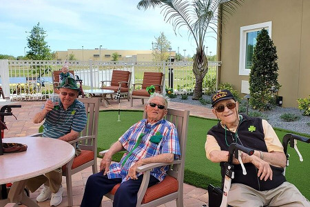 3 seniors sitting by mini-golf course