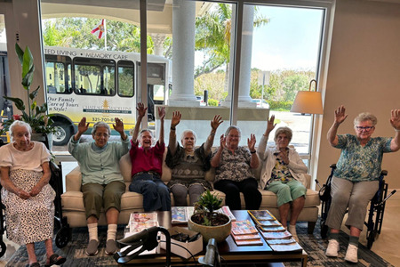 smiling senior ladies with their arms up