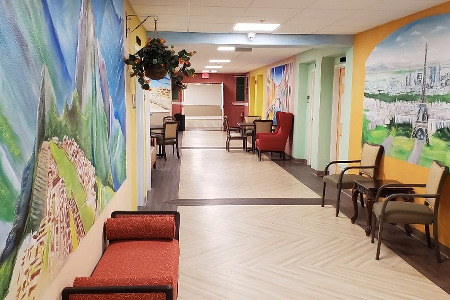 Hallway with chairs and paintings on wall