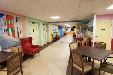 Multi-colored hallway with two doors, tables and chairs