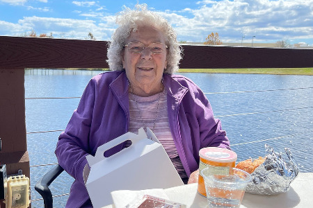 Senior woman eating at dock