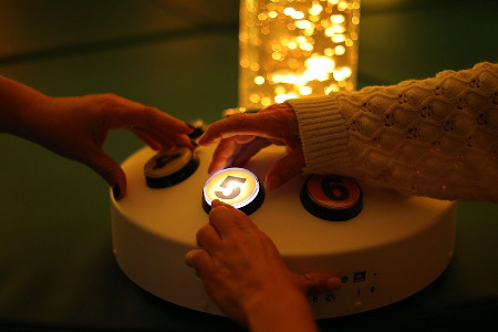 Hands touching sensory machine buttons