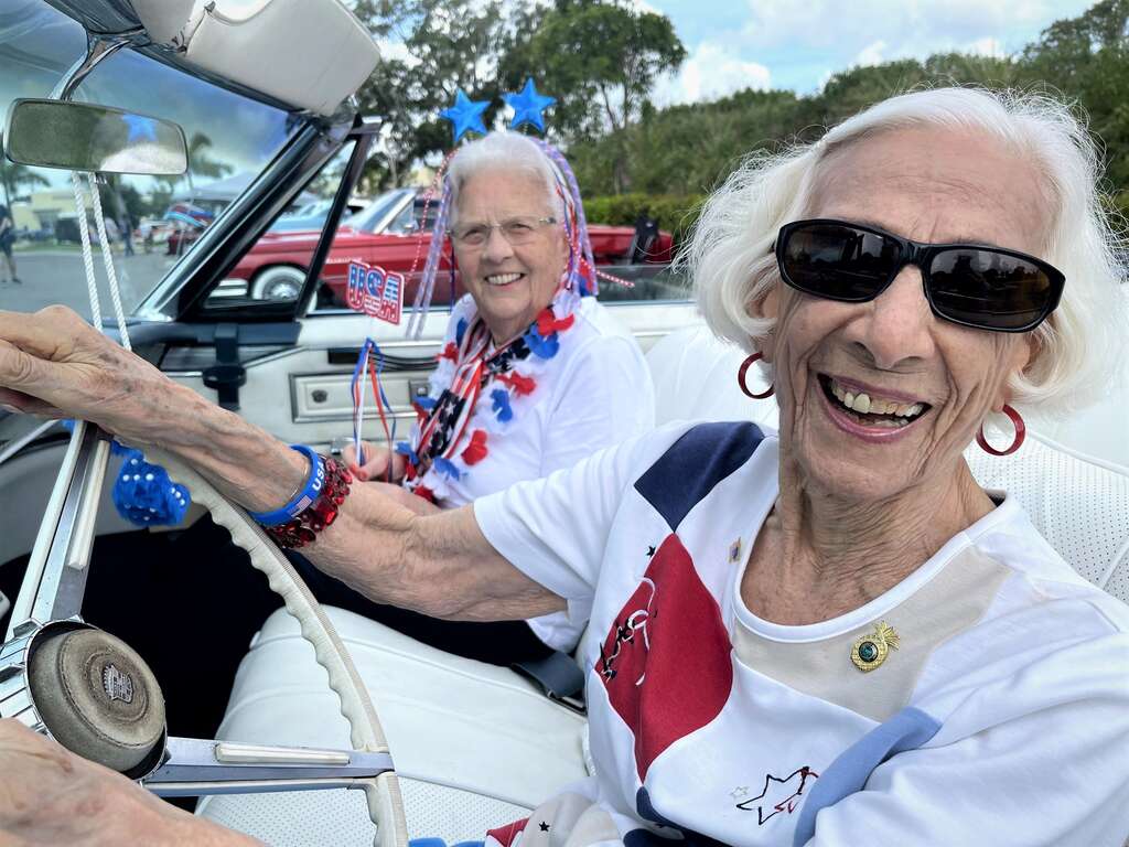 senior women residents laughing classic car show
